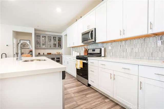 a kitchen with stainless steel appliances a sink dishwasher stove refrigerator and cabinets