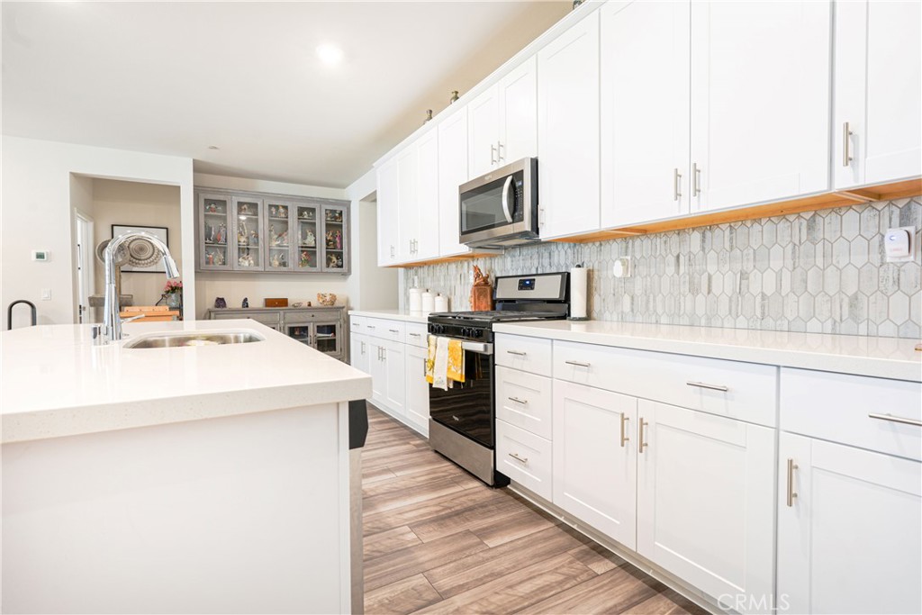 15630 Raptor Road Moreno Valley, CA 92551 - Photo 6 of 25 a kitchen with stainless steel appliances a sink dishwasher stove refrigerator and cabinets