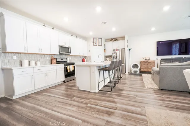 a view of kitchen with stainless steel appliances refrigerator oven and cabinets