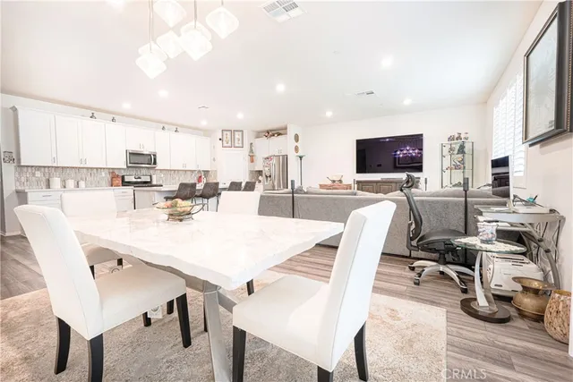 a dining room with furniture a large window and a chandelier