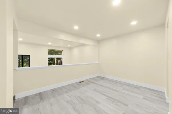 a view of empty room with wooden floor