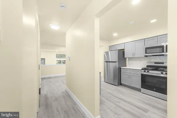 a view of a kitchen with a refrigerator a stove top oven and cabinets