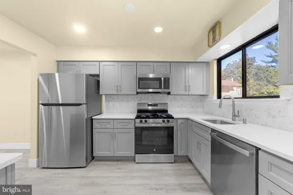 a kitchen with stainless steel appliances granite countertop a refrigerator sink and stove