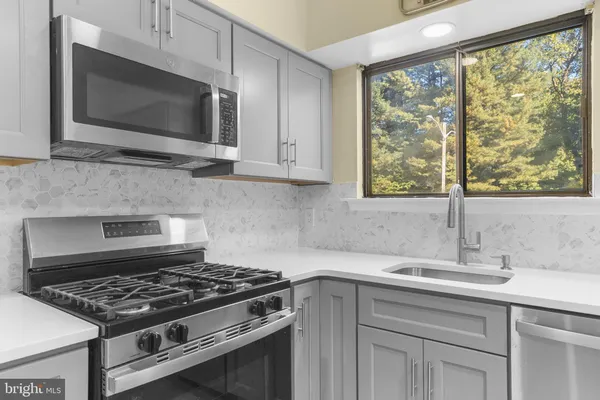 a kitchen with granite countertop a sink stainless steel appliances and cabinets