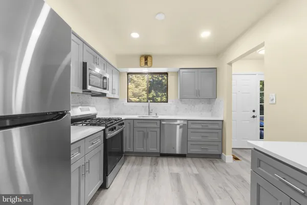 a kitchen with granite countertop a sink stove and refrigerator