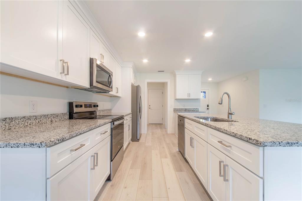 500 9th Street Northeast Fort Meade, FL 33841 - Photo 16 of 33 a large kitchen with stainless steel appliances granite countertop a sink stove and cabinets