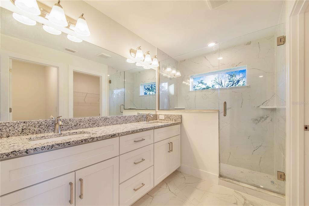 500 9th Street Northeast Fort Meade, FL 33841 - Photo 24 of 33 a bathroom with a granite countertop sink a mirror and a shower