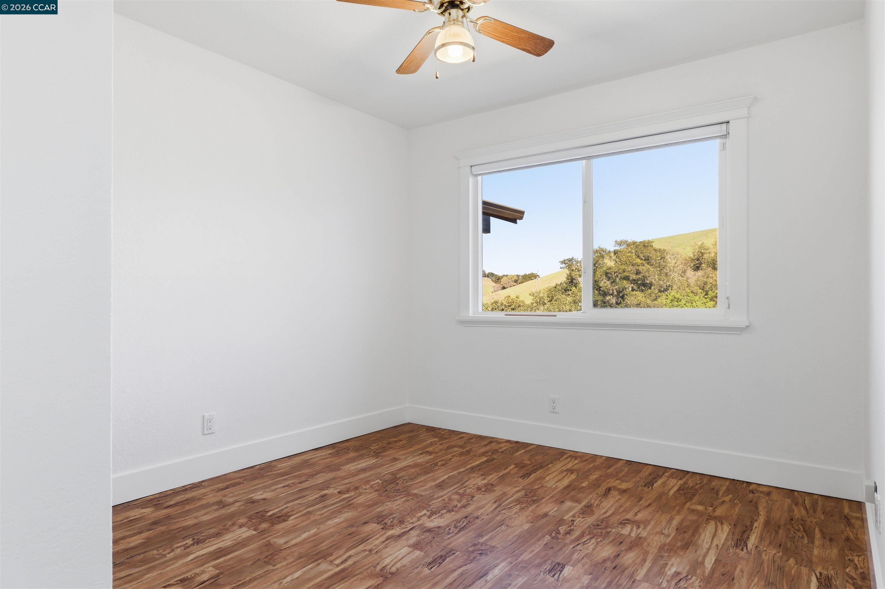 9530 Morgan Territory Road Livermore, CA 94551 - Photo 26 of 55 an empty room with a ceiling fan and wooden floor