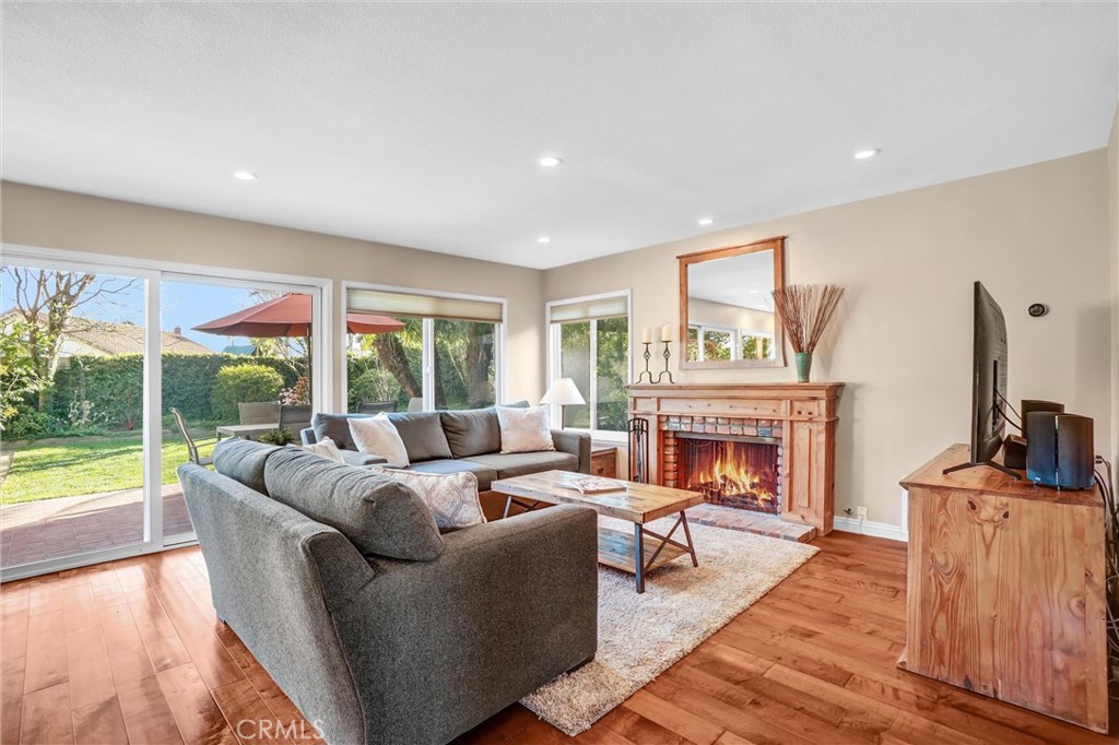 5552 Ridgebury Drive Huntington Beach, CA 92649 - Photo 11 of 31 a living room with furniture a fireplace and a floor to ceiling window