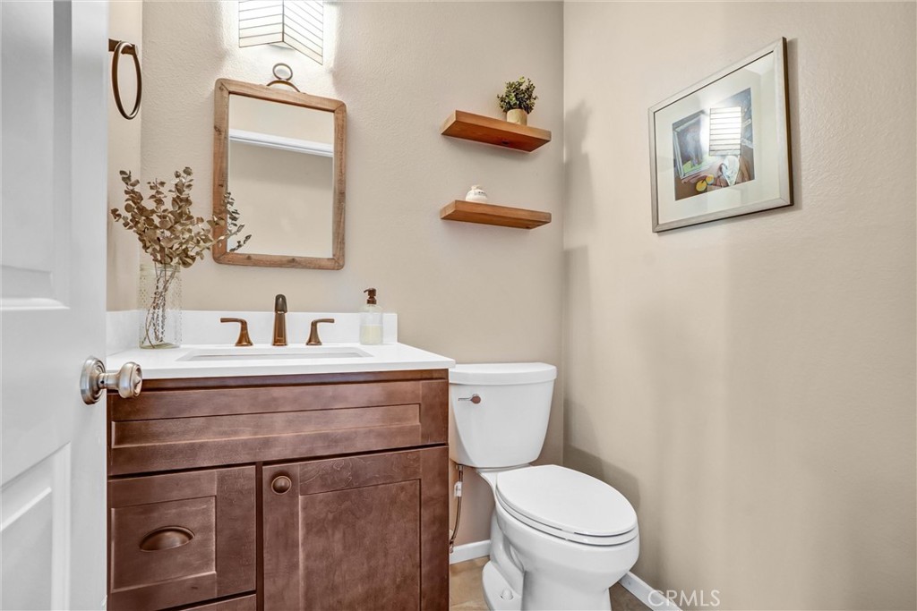 5552 Ridgebury Drive Huntington Beach, CA 92649 - Photo 13 of 31 a bathroom with a toilet a sink and mirror