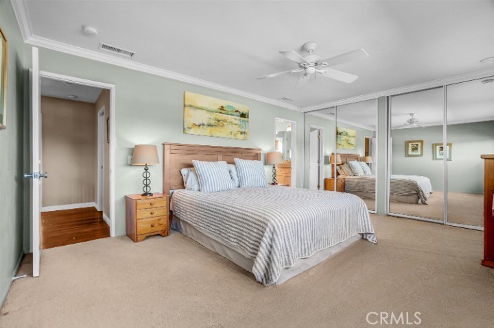 5552 Ridgebury Drive Huntington Beach, CA 92649 - Photo 16 of 31 a spacious bedroom with a bed and ceiling fan