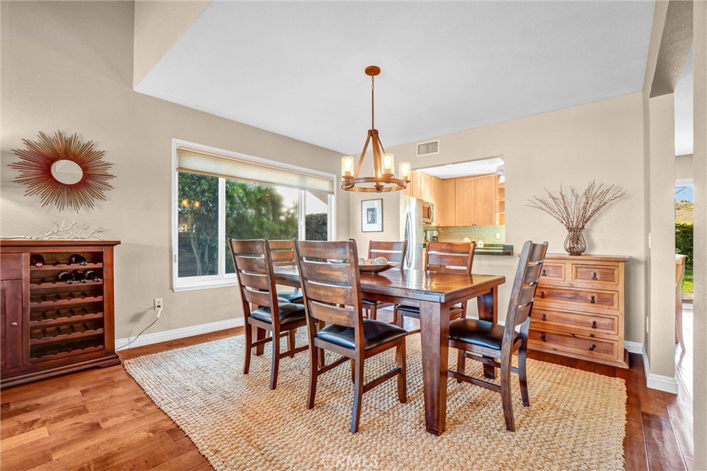 5552 Ridgebury Drive Huntington Beach, CA 92649 - Photo 7 of 31 a dining room with furniture a chandelier and wooden floor