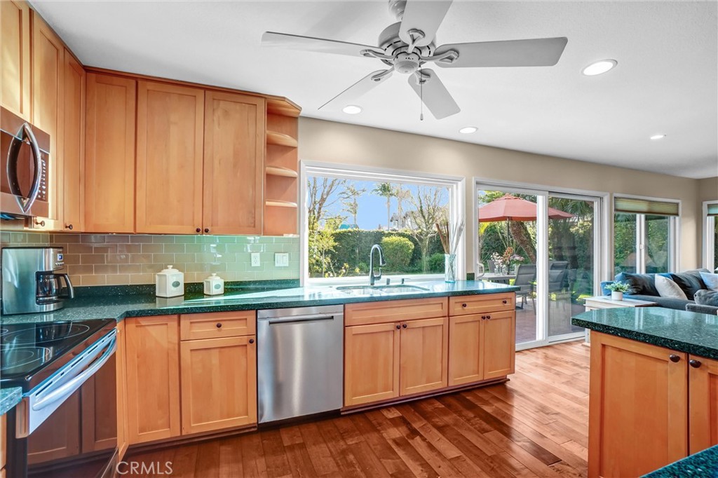5552 Ridgebury Drive Huntington Beach, CA 92649 - Photo 8 of 31 a kitchen with stainless steel appliances granite countertop wooden cabinets a sink a stove and a refrigerator
