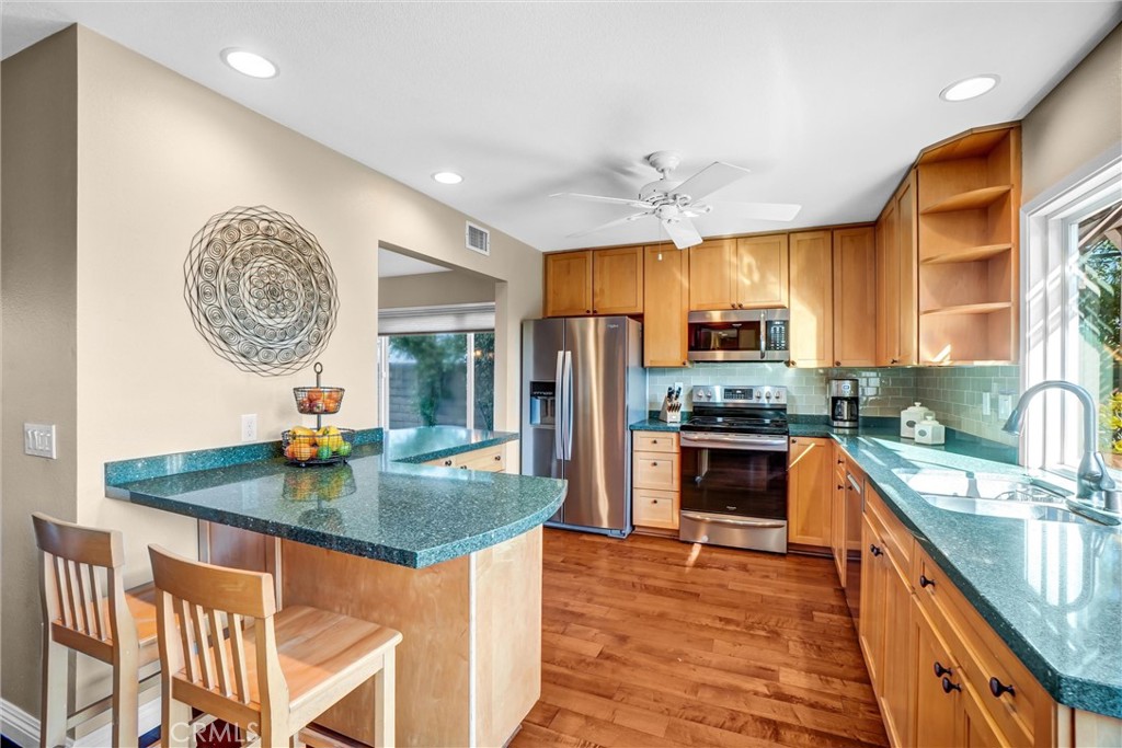 5552 Ridgebury Drive Huntington Beach, CA 92649 - Photo 10 of 31 a kitchen with stainless steel appliances granite countertop a sink a stove and a wooden floors