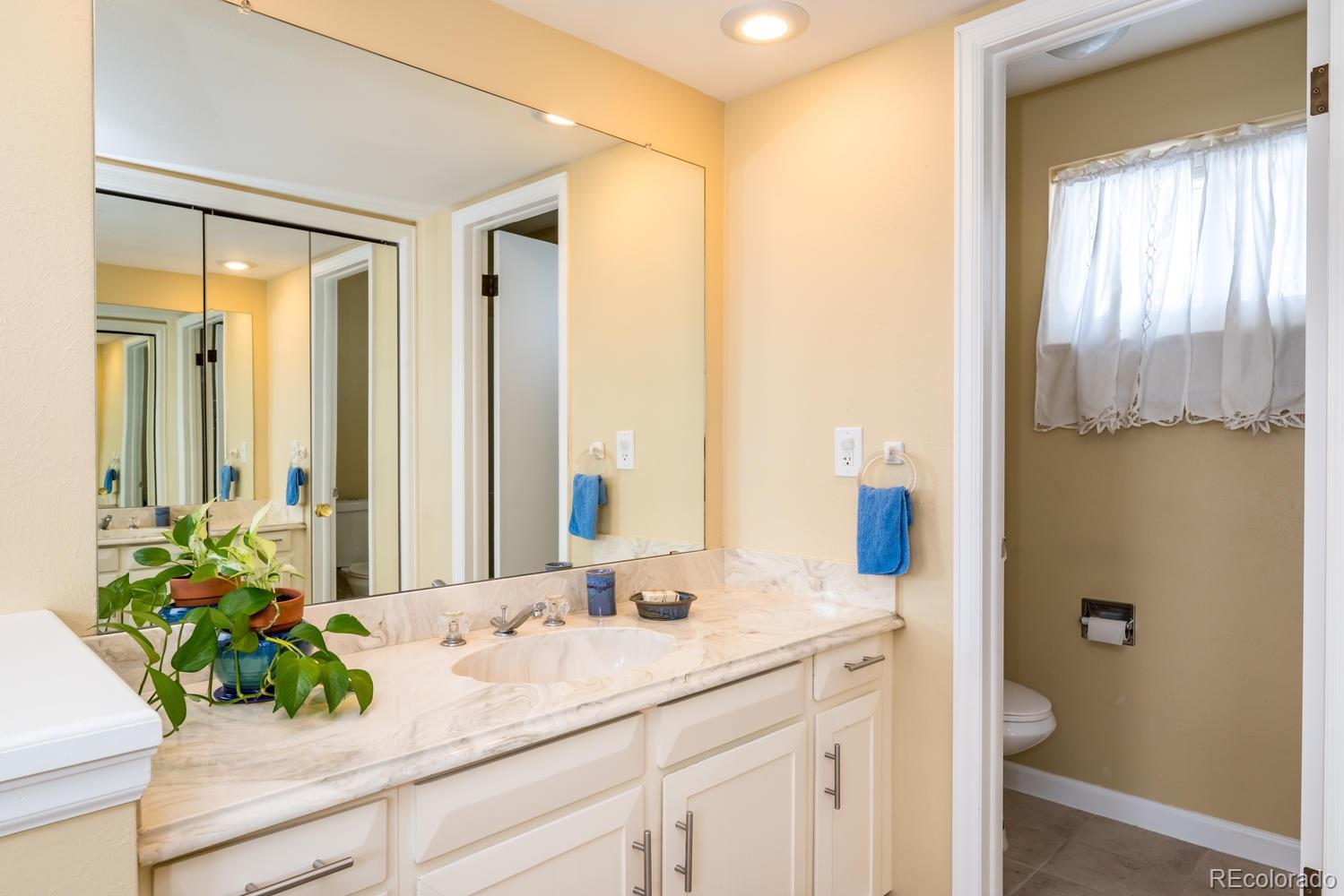 4311 Carter Trail Boulder, CO 80301 - Photo 21 of 35 a bathroom with a granite countertop sink a mirror and a shower curtain