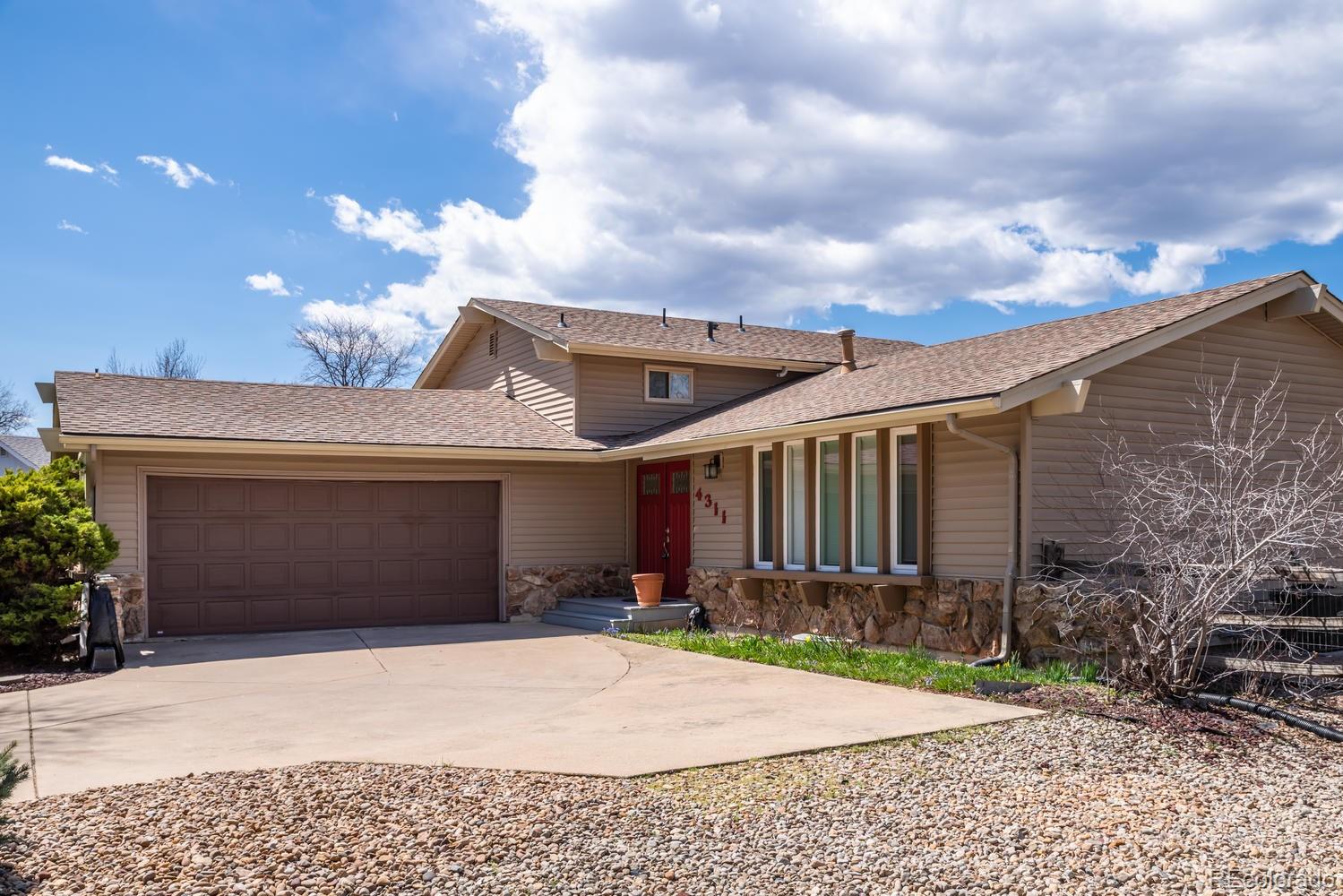 4311 Carter Trail Boulder, CO 80301 - Photo 3 of 35 a front view of a house with a yard and garage