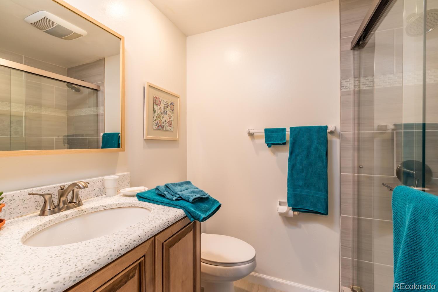 4311 Carter Trail Boulder, CO 80301 - Photo 31 of 35 a bathroom with a granite countertop sink a toilet a mirror and shower