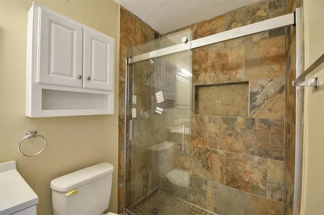 a bathroom with a shower a toilet and sink