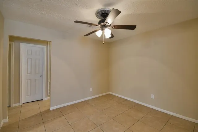 an empty room with a chandelier fan and closet