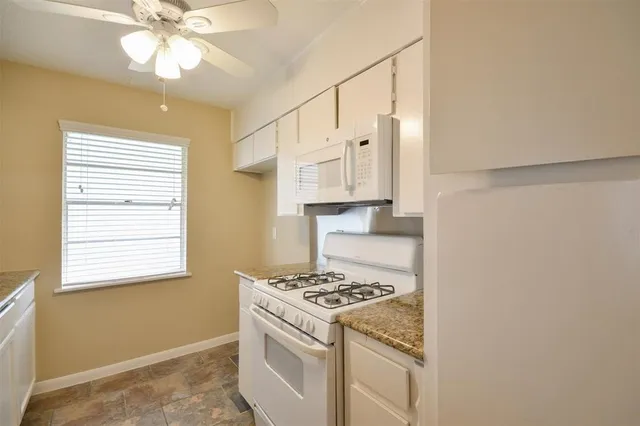 a kitchen with cabinets appliances and a window