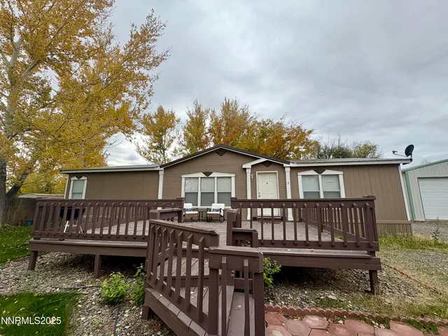 a view of a house with wooden deck front of house