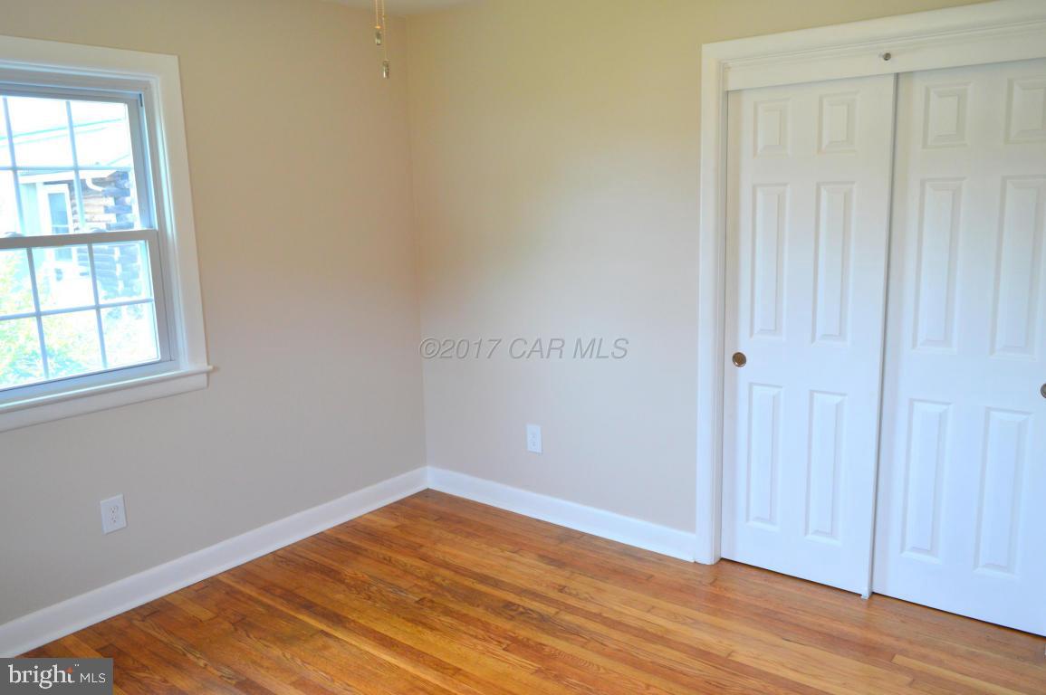 20306 Nanticoke Road Nanticoke, MD 21840 - Photo 19 of 24 an empty room with wooden floor and windows
