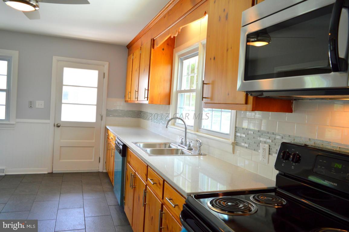 20306 Nanticoke Road Nanticoke, MD 21840 - Photo 4 of 24 a kitchen with kitchen island granite countertop a sink stove and cabinets