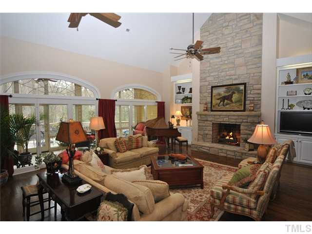 1104 Hymettus Court Raleigh, NC 27607 - Photo 7 of 25 Enjoy cozy evenings in this comfortable room embellished by floor to ceiling stone fireplace, wet bar, elliptical transom windows, built-ins, French doors and stunning columns defining the space. OPEN TO THE KITCHEN!
