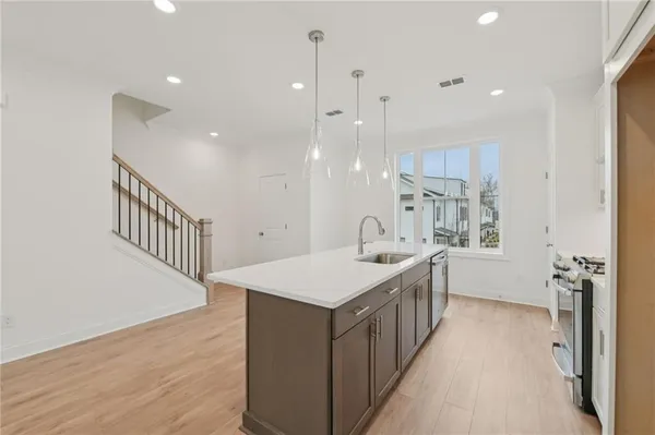 a kitchen with stainless steel appliances a stove a sink and cabinets