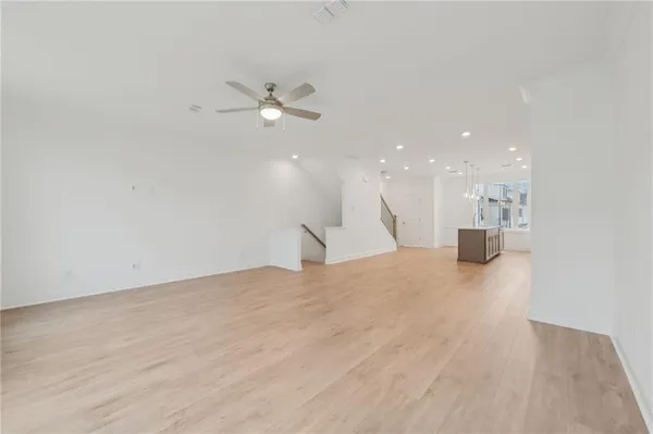 a large kitchen with kitchen island a stove a sink a refrigerator and white cabinets