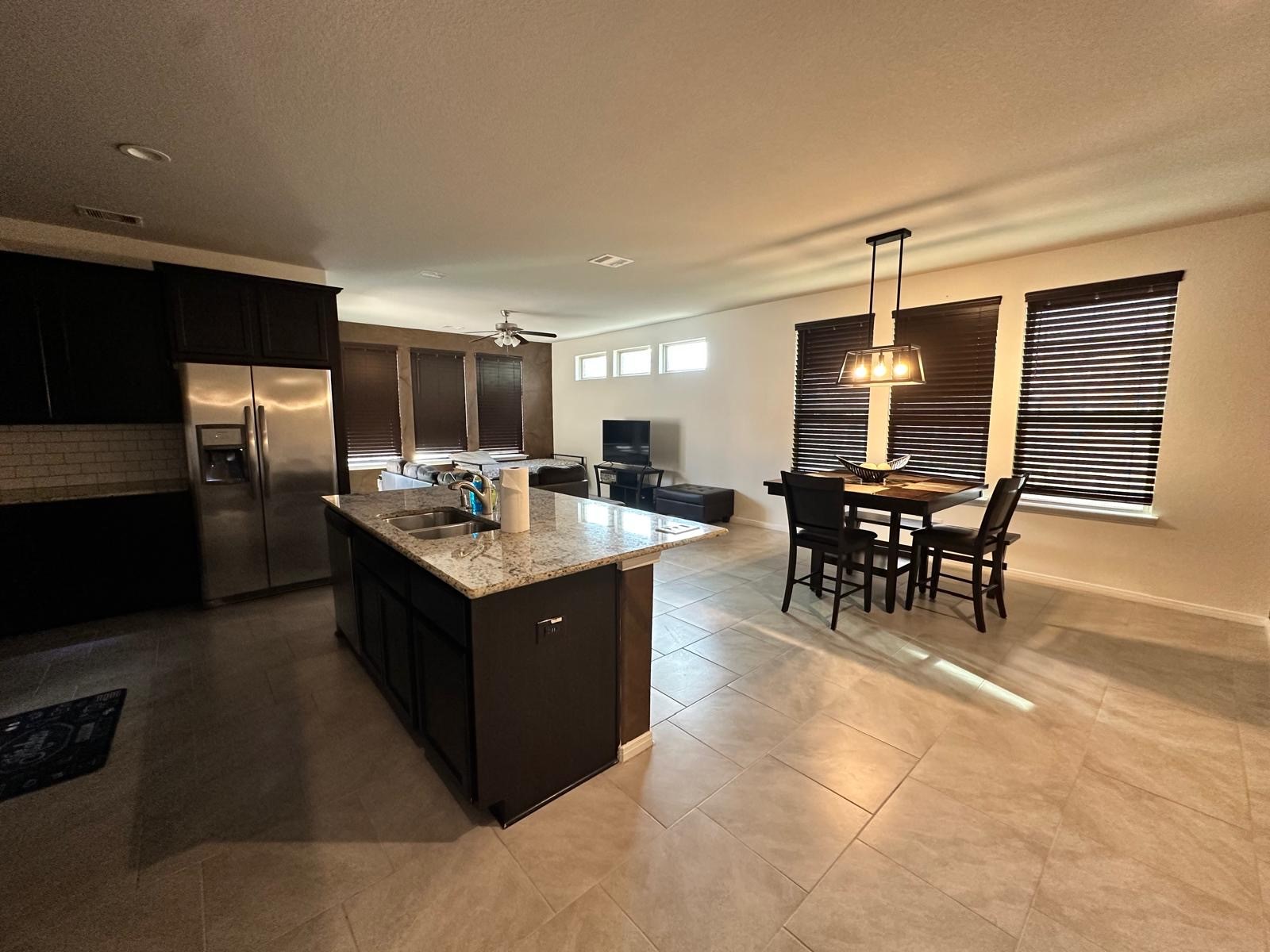 3322 Harvest Meadow Lane Rosenberg, TX 77471 - Photo 2 of 39 a kitchen with stainless steel appliances kitchen island granite countertop a table chairs and a refrigerator