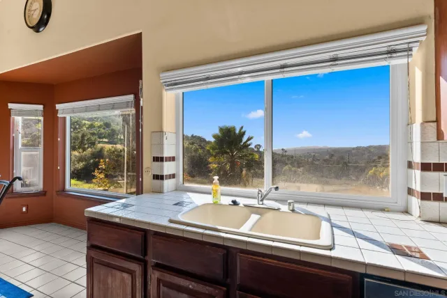 a view of an empty room with glass door and wooden floor