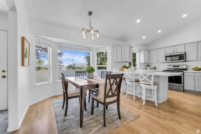 1147 West State Road Lehi, UT 84043 - Photo 6 of 31 Open-concept dining area and kitchen featuring wood-finish flooring, a bay window, and a vaulted ceiling