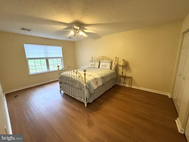 a spacious bedroom with a bed chandelier and a window