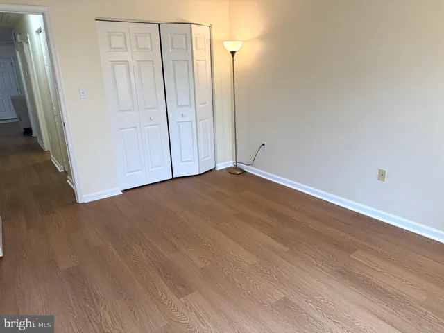 a view of an empty room with wooden floor