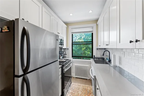 a kitchen with stainless steel appliances granite countertop a refrigerator a sink and a stove