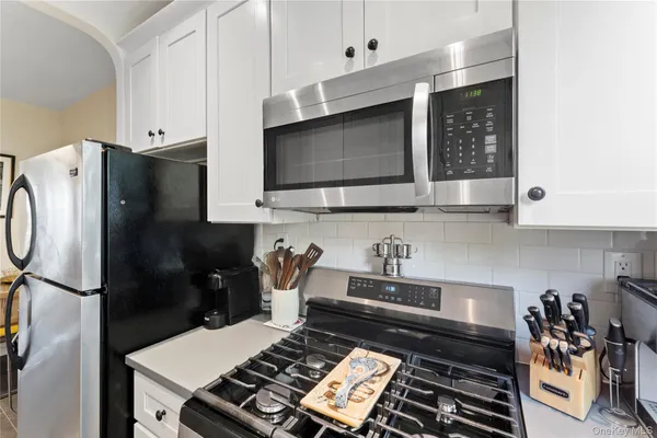 a kitchen with stainless steel appliances a stove a sink and a microwave