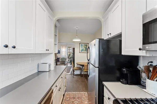 a kitchen with stainless steel appliances a refrigerator sink and white cabinets