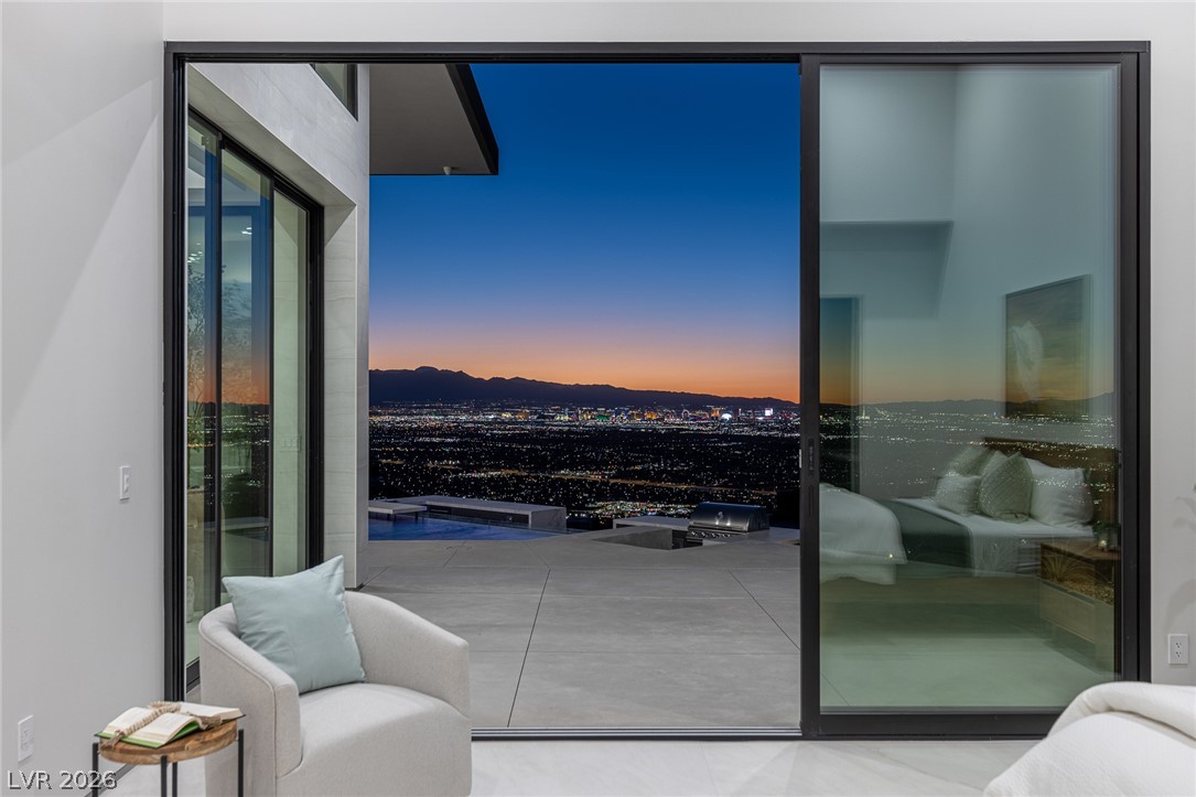 563 Grand Rim Drive Henderson, NV 89012 - Photo 49 of 70 Dramatic cityscape vistas unfold from this modern home's expansive glass doors, offering an unparalleled evening backdrop.
