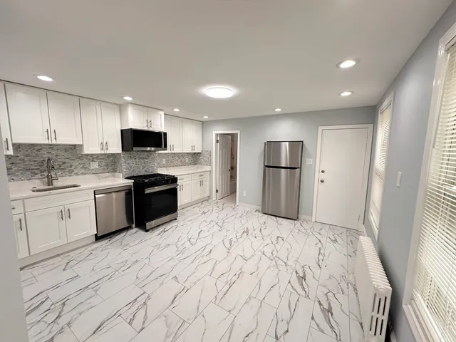 a large kitchen with a stove sink and refrigerator
