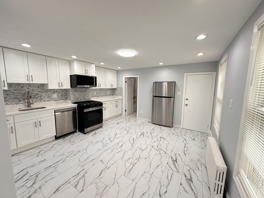 a large kitchen with a stove sink and refrigerator