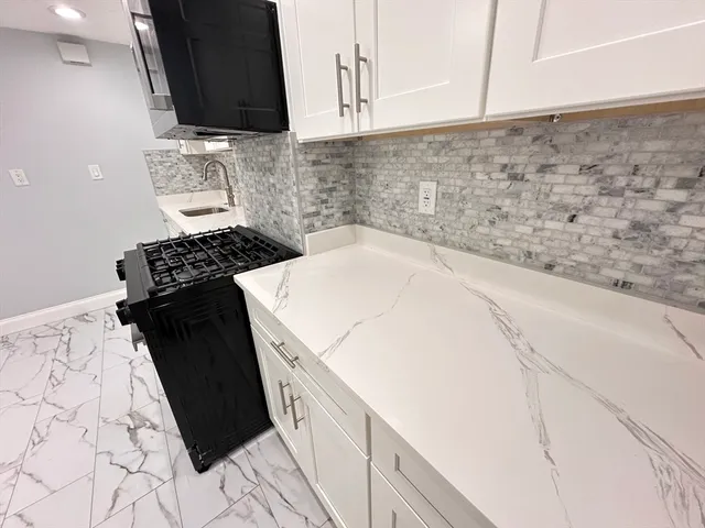 a kitchen with a sink and a stove top oven