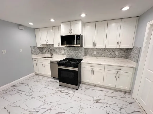 a kitchen with white cabinets stainless steel appliances and sink
