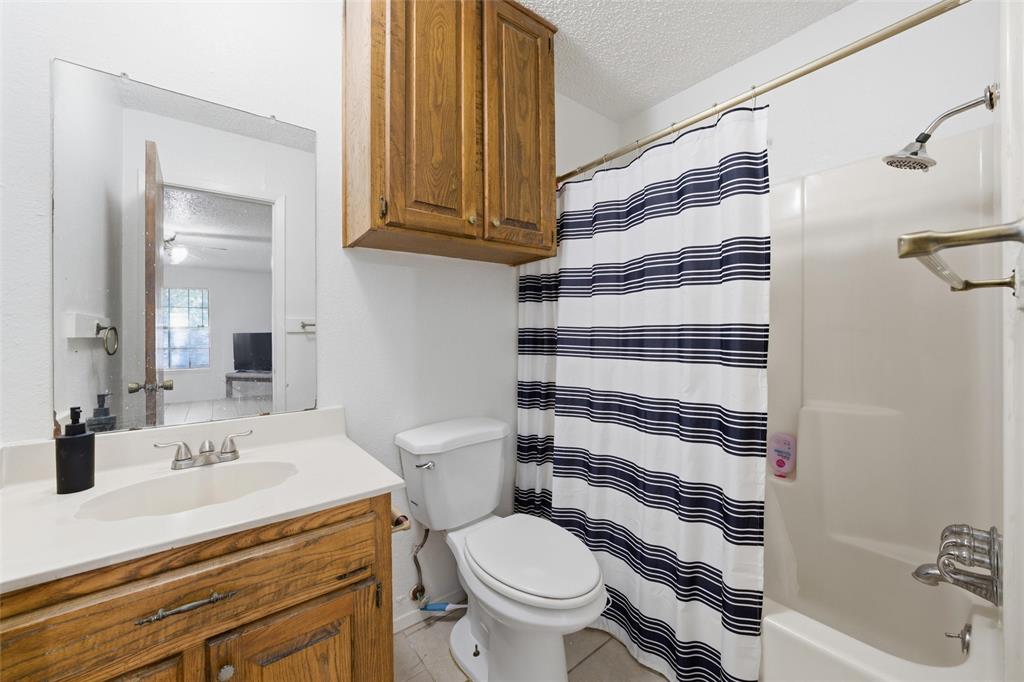 1507 McFerrin Avenue, Unit 9 Waco, TX 76708 - Photo 12 of 26 a bathroom with a sink a toilet and shower curtain