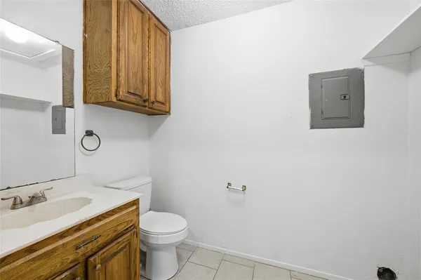 a bathroom with a granite countertop toilet and sink