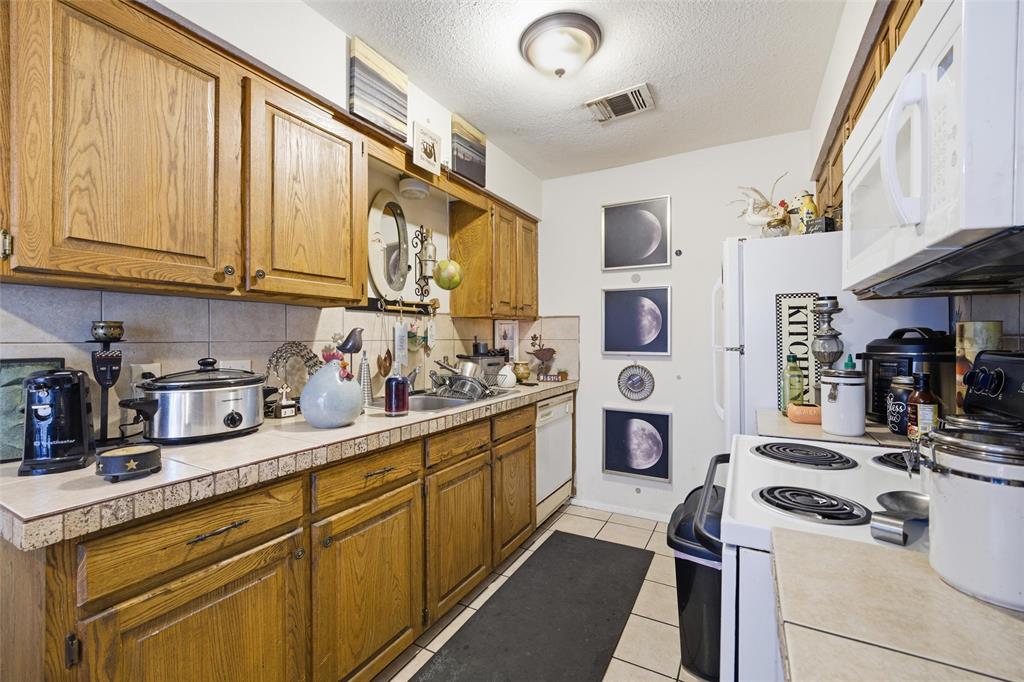 1507 McFerrin Avenue, Unit 9 Waco, TX 76708 - Photo 18 of 26 a kitchen with stainless steel appliances granite countertop a sink and cabinets