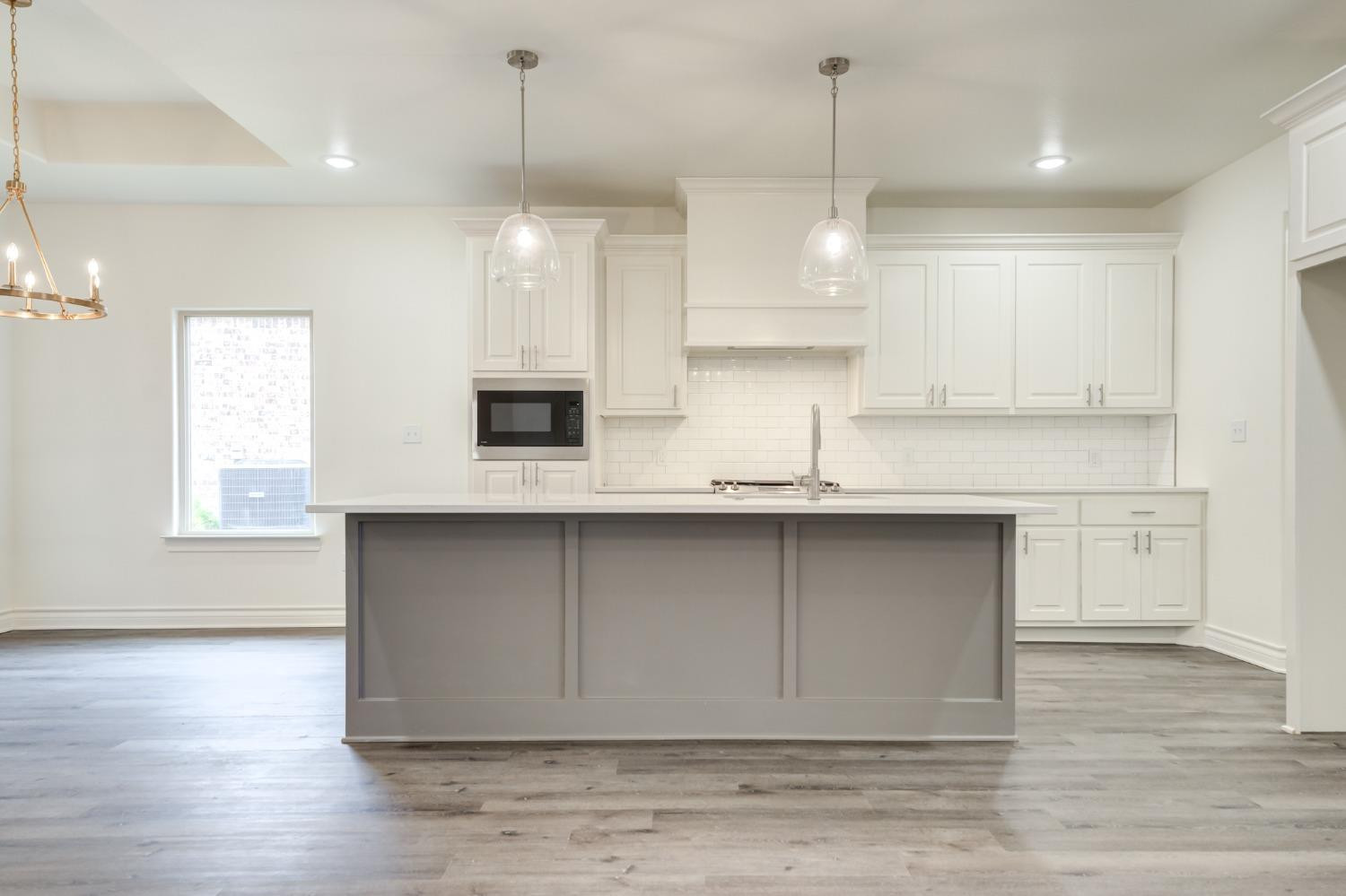 3712 144th Street Lubbock, TX 79423 - Photo 12 of 46 a kitchen with kitchen island white cabinets and stainless steel appliances