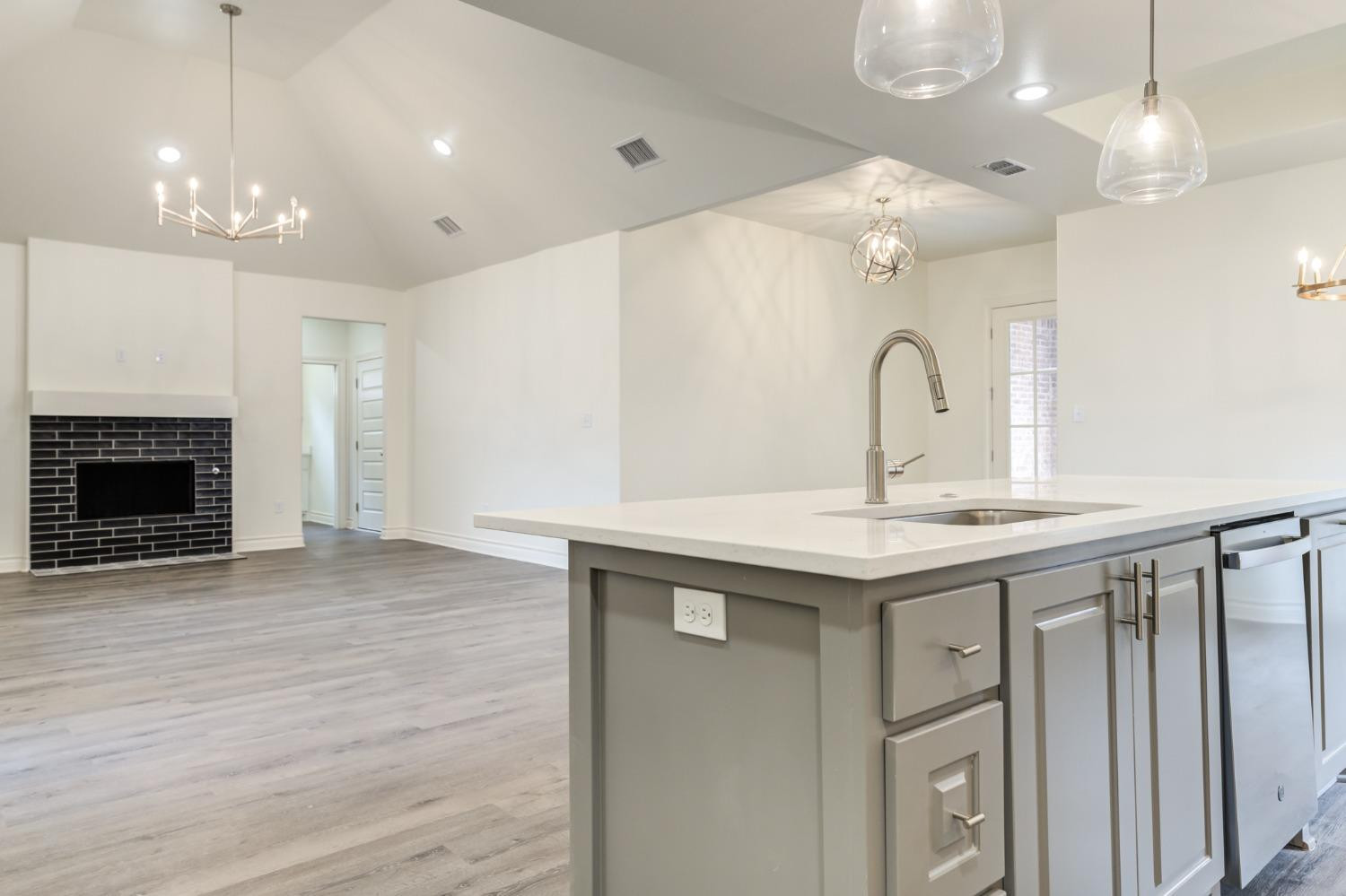 3712 144th Street Lubbock, TX 79423 - Photo 17 of 46 a kitchen with a sink chandelier and a fireplace