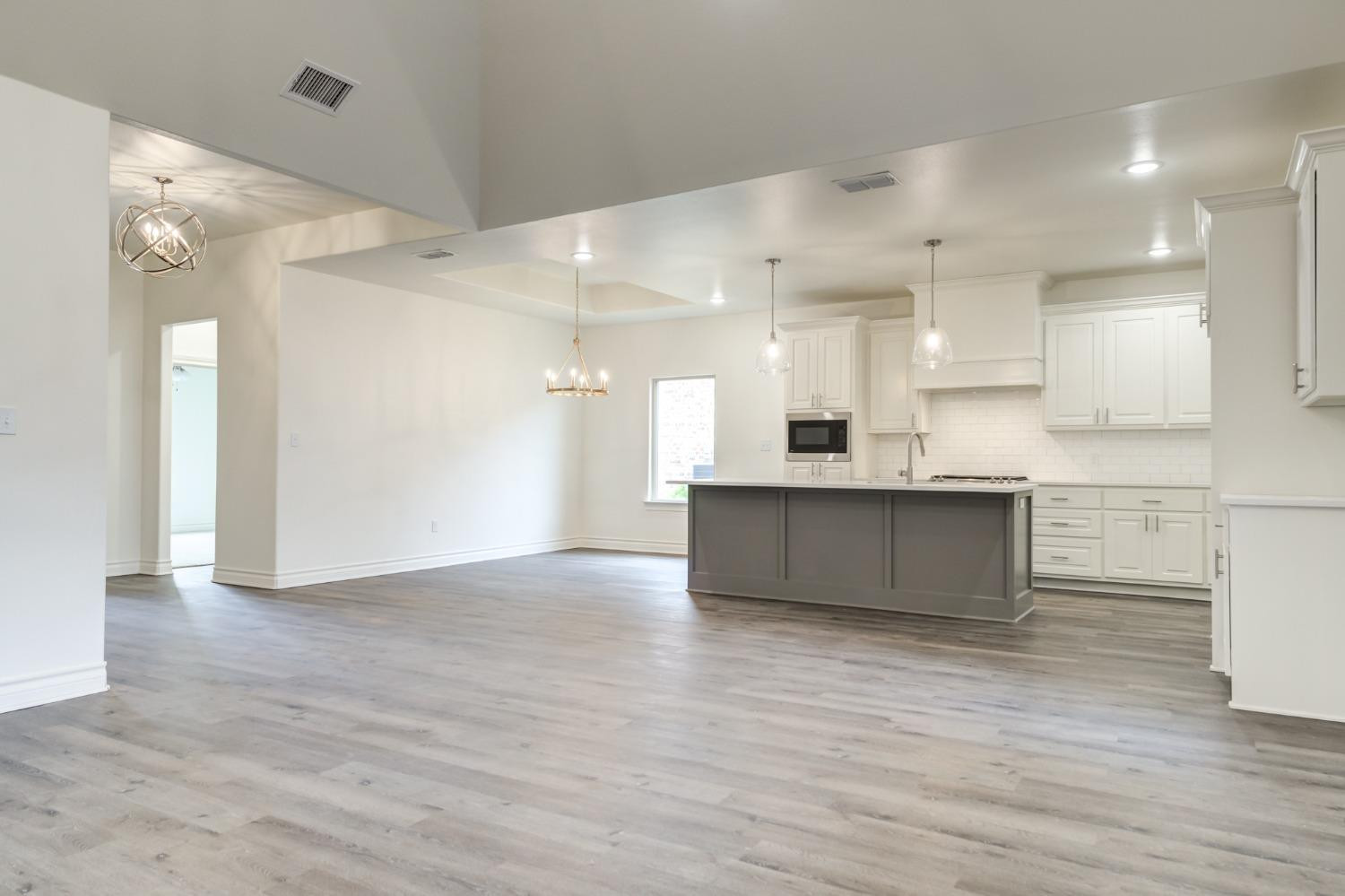 3712 144th Street Lubbock, TX 79423 - Photo 28 of 46 a view of large kitchen with kitchen island wooden floors stainless steel appliances and cabinets
