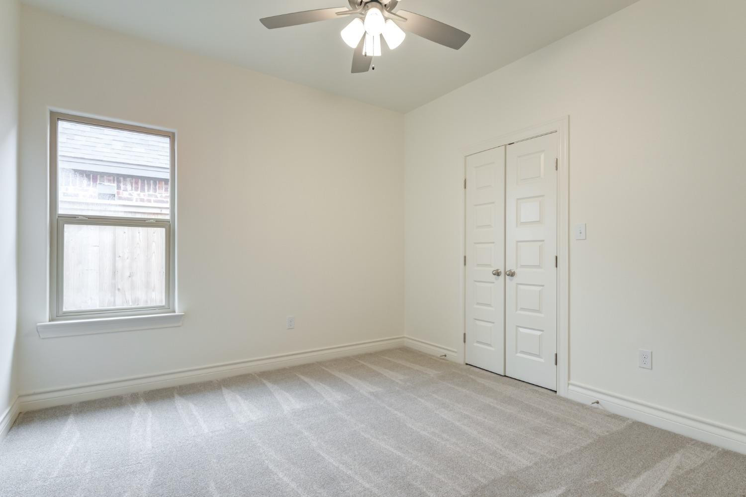 3712 144th Street Lubbock, TX 79423 - Photo 31 of 46 an empty room with a chandelier fan and windows